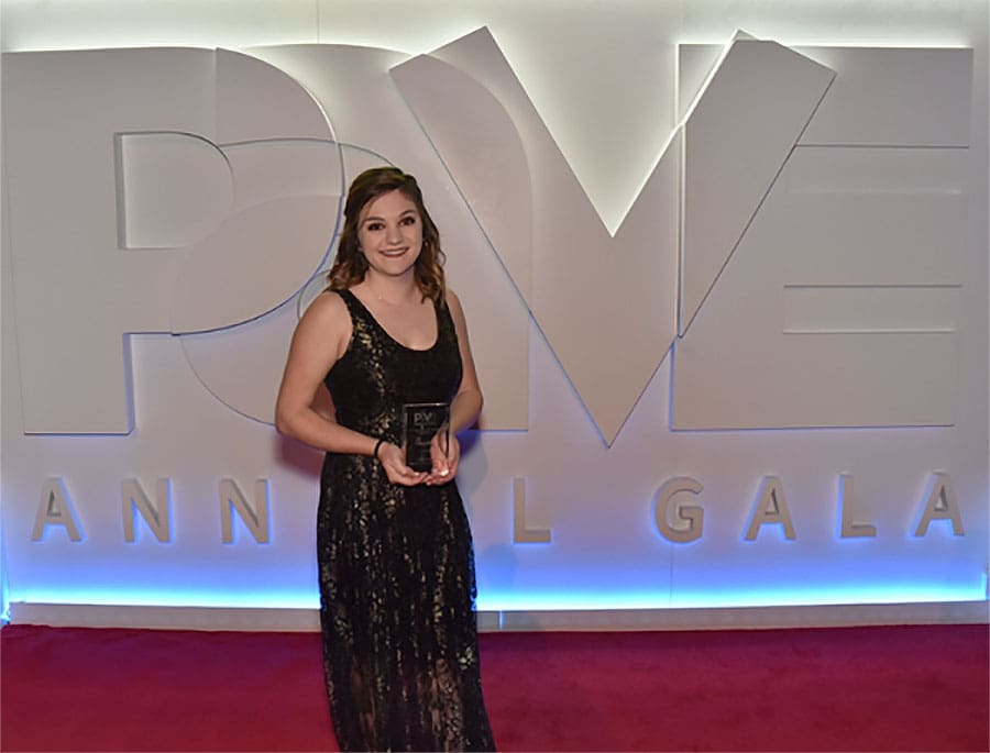 Emma Morris holding award in-front of PAVE logo