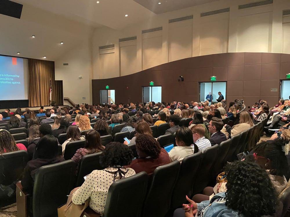 People seated in an auditorium, listening to a presentation at the 2023 Behavioral Health Convening