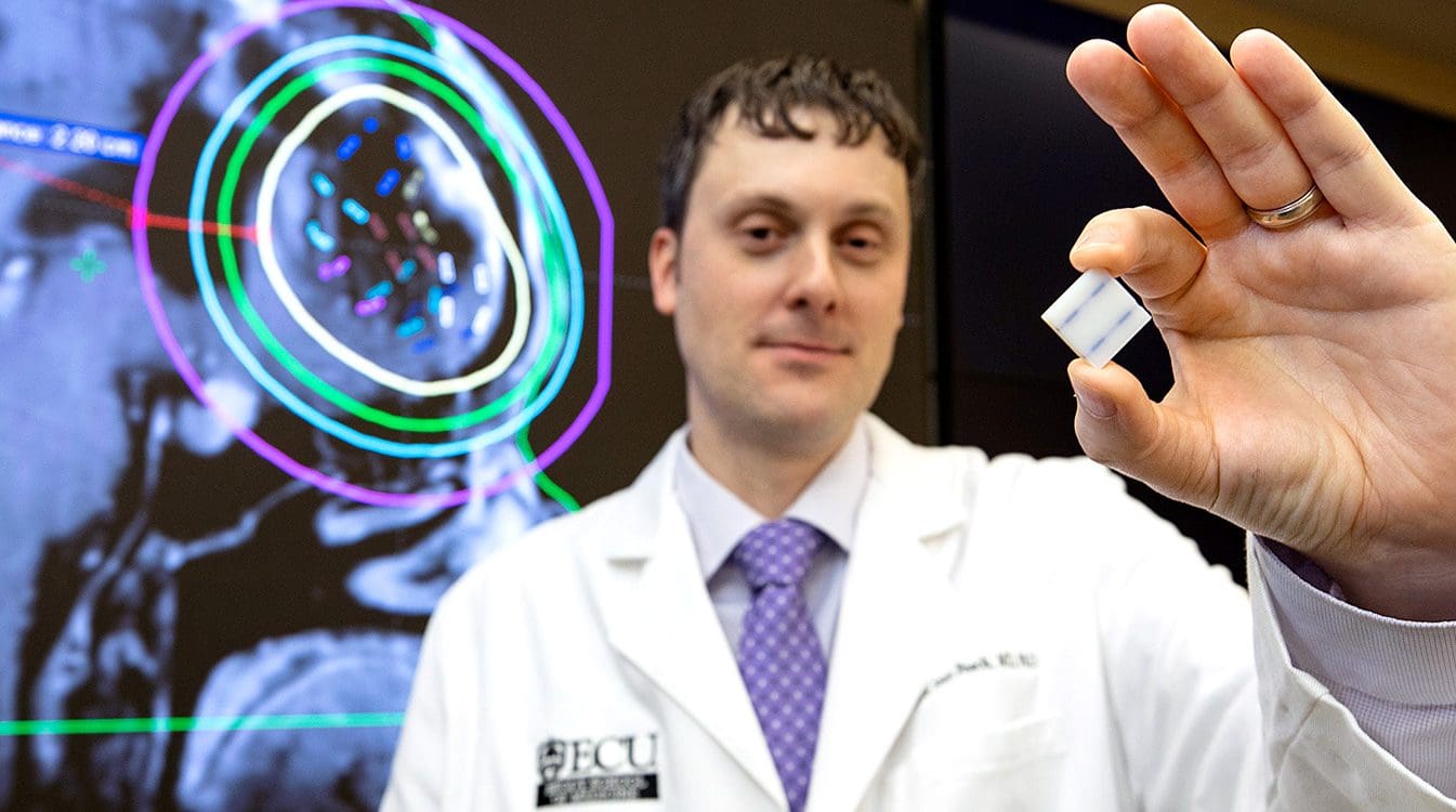 Dr. Matthew Sean Peach, an assistant professor in the Department of Radiation Oncology at ECU’s Brody School of Medicine, holds a Gammatile used to treat brain tumors.
