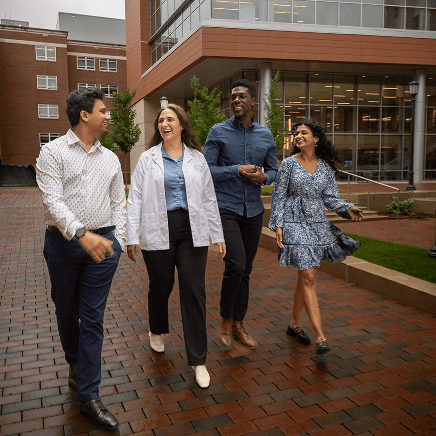 Four smiling medical students walking on campus at UNC-Chapel Hill