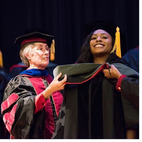 De'Sember Phillips receives her hood from (left) Dr. Lynn Millar and Dr. Emma White during the December 2017 Doctor of Physical Therapy ceremony.