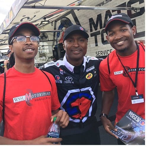 WSSU Motorsports Management students (left) Sidney Pritchett and Walter Thomas III (right) with NHRA driver Antron Brown.