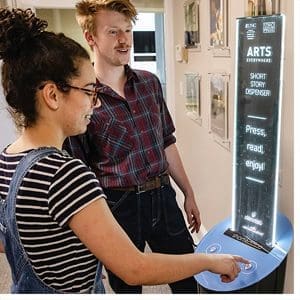 Seniors Elina Rodriguez and Hampton Smith use a vending machine that dispenses short stories on April 5 in South Building. (Johnny Andrews/UNC-Chapel Hill)