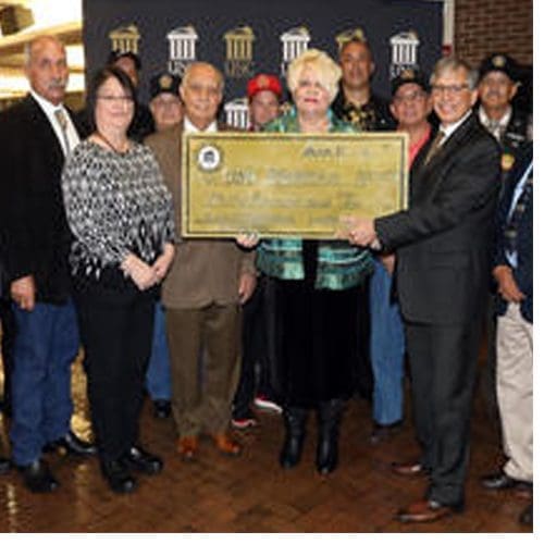 Representatives with LREMC and Lumbee Warriors Association present Chancellor Robin Gary Cummings with a $30,000 check to establish a scholarship for veterans' descendants