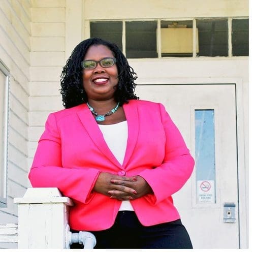 Dr. Melissa Stuckey, ECSU professor of history, stands in front of the Rosenwald School building on campus. ECSU was just awarded a National Endowment for the Humanities grant to help renovate this and the Prinicpal’s House for a planned African American American Research and Cultural Heritage Center.