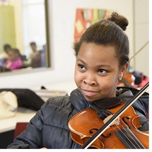 The Professional Development for Arts Educators grant is a natural extension of the College of Visual and Performing Arts' community-engaged work with local schools. In the photo above, a student learns violin as part of the Arts After School initiative.