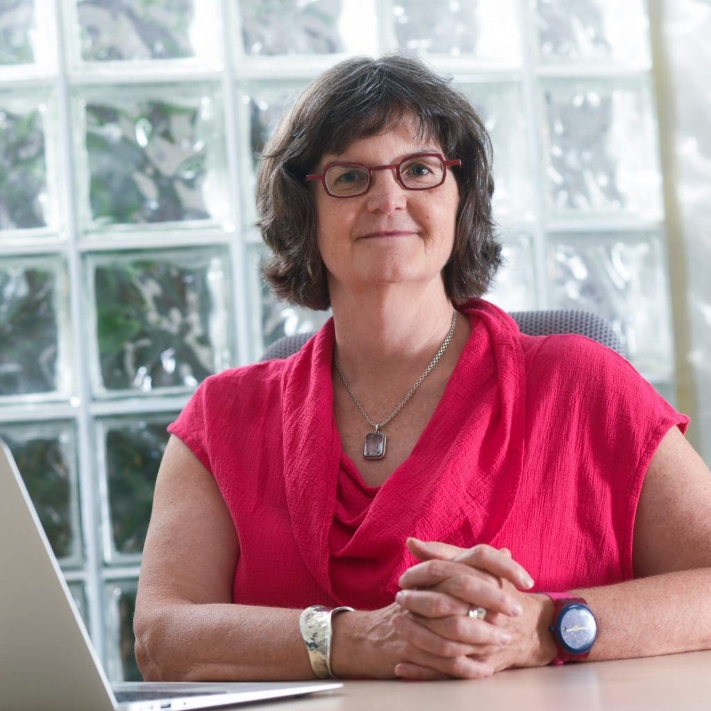 Dr. Jane Hoppin seated at a table and smiling