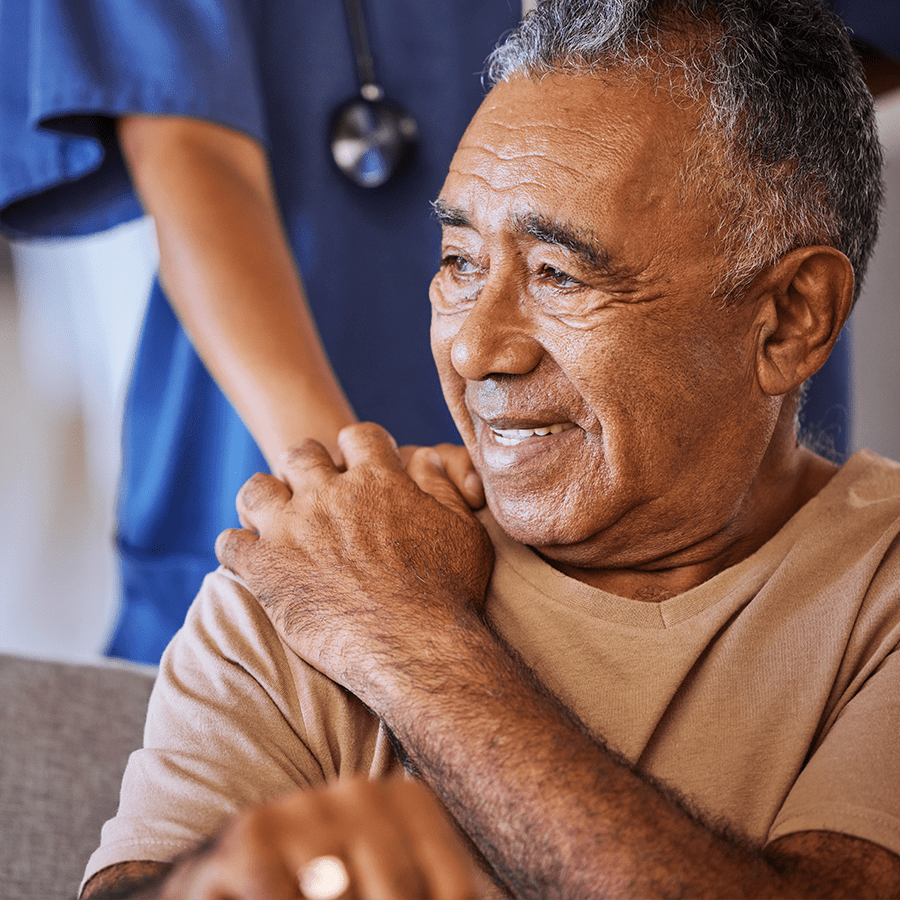 Nurse or doctor holding hand of her senior patient while doing a checkup at a hospital.