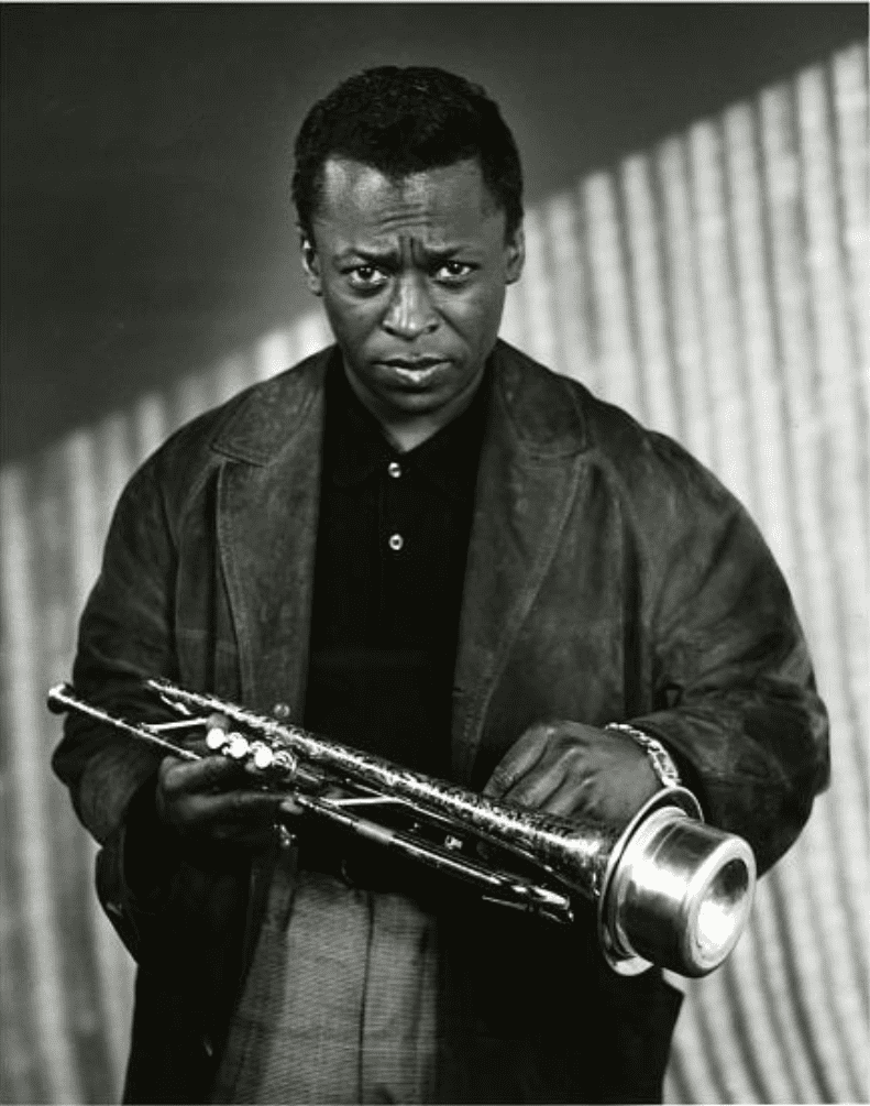 Miles Davis holds a muted trumpet