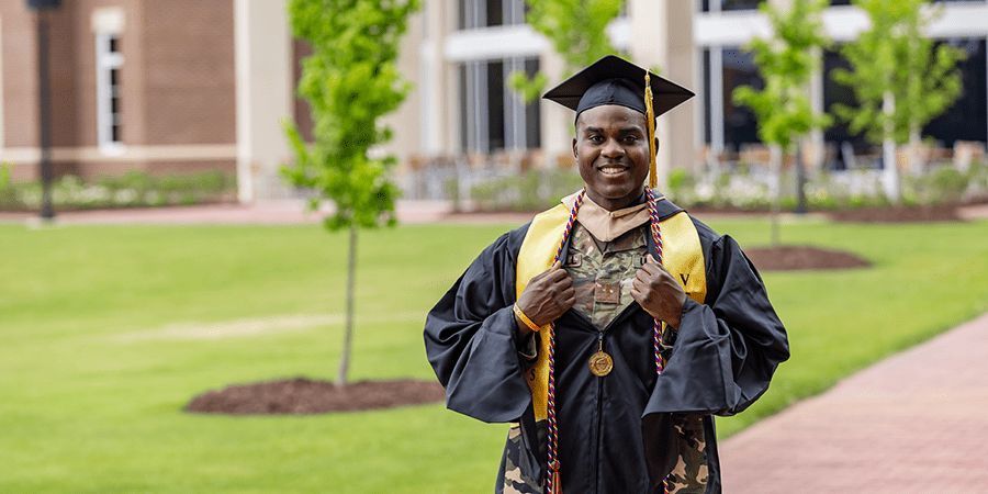 Smiling graduate wearing a cap and down over a military uniform