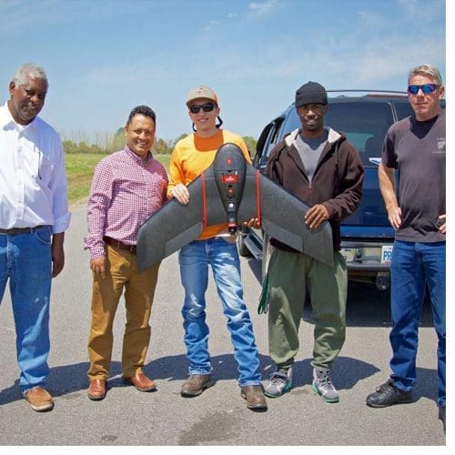 Undergraduate aviation students Weston Smith, center left, and Leon Davis, center right, join aviation faculty members Dr. Ellis Lawrence, far left, Dr. Kuldeep Rawat, second from left, and Aron Bechiom, far right, the drone lab technician and pilot, on a field test of various professional and research drones.